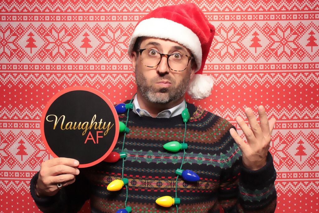 man-in-santa-hat-and-sweater-holding-signs-at-smash-booth-las-vegas