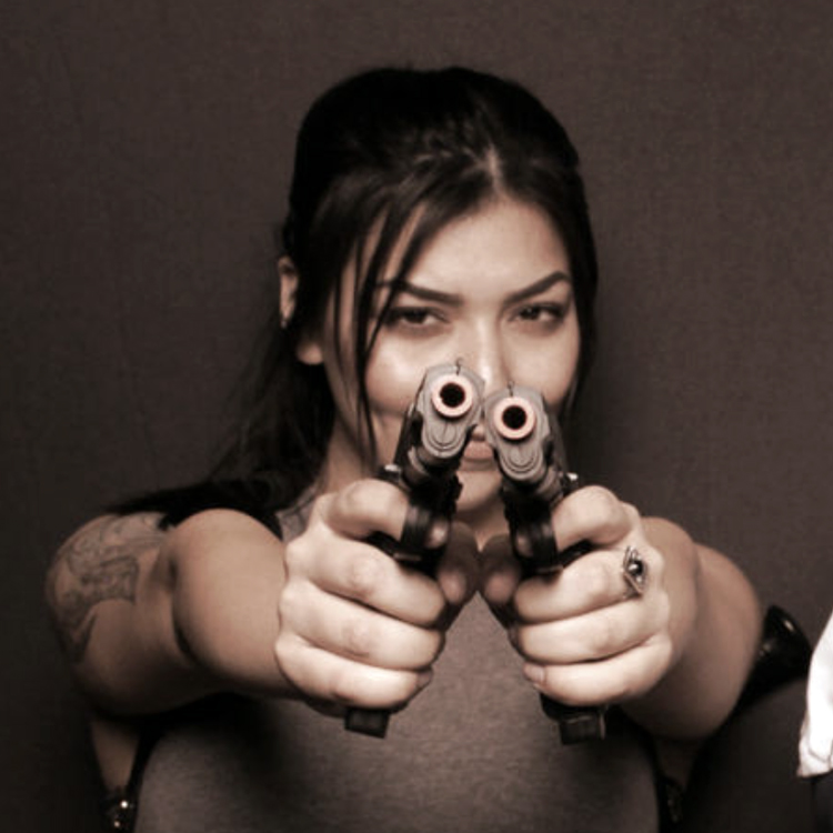 woman-pointing-to-camera-holding-prop-guns-in-photo-booth