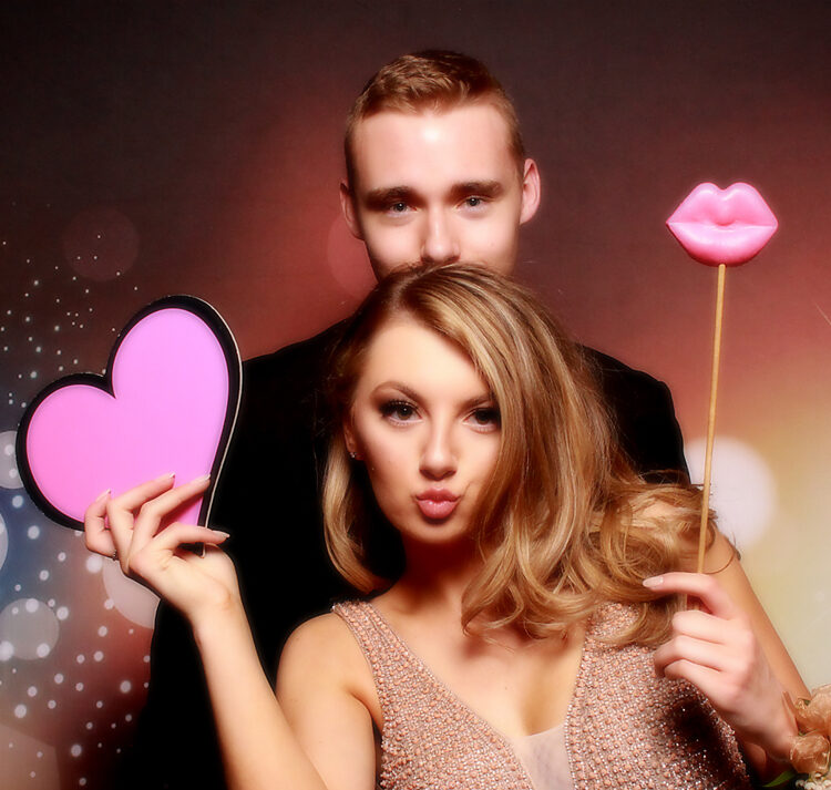 woman-and-man-posing-with-heart-prop-in-smash-booth-photo-booth