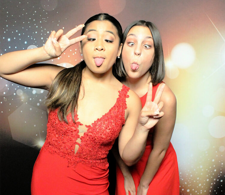 two-women-making-fun-faces-in-school-prom-photo-booth