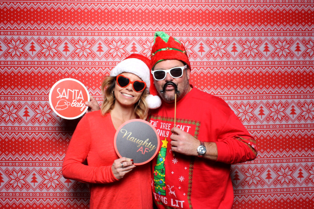 two-men-in-holiday-sweaters-holding-santa-and-naughty-signs-at-smash-booth-las-vegas